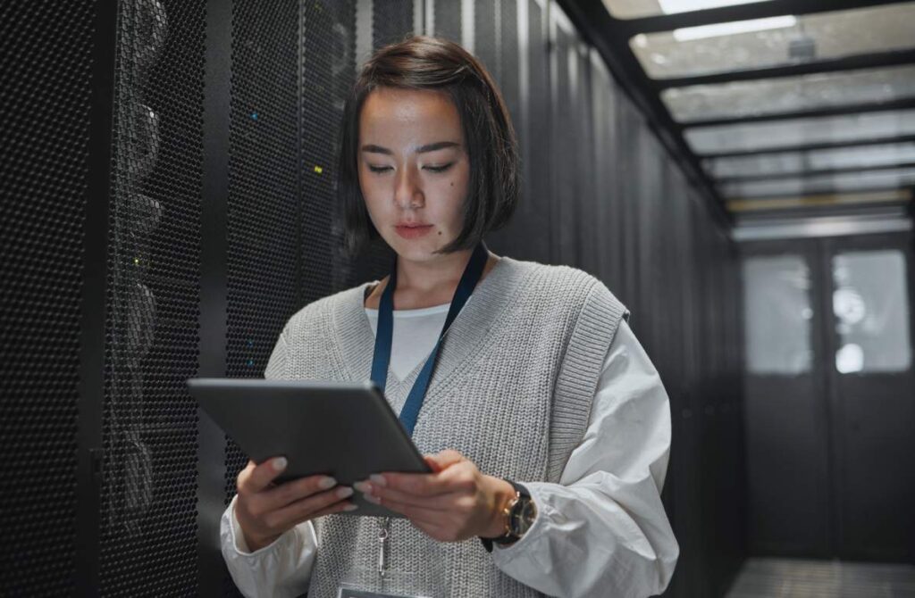 A systems administrator using a tablet in a secure server room