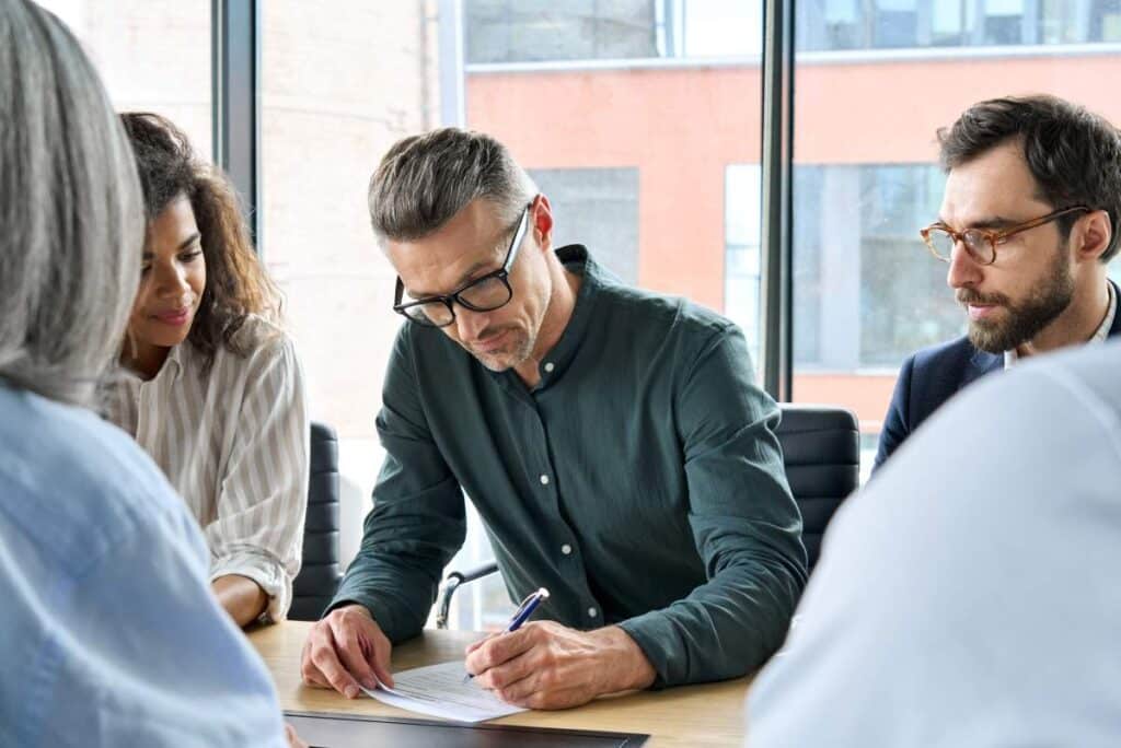 A group meets to sign an escrow agreement