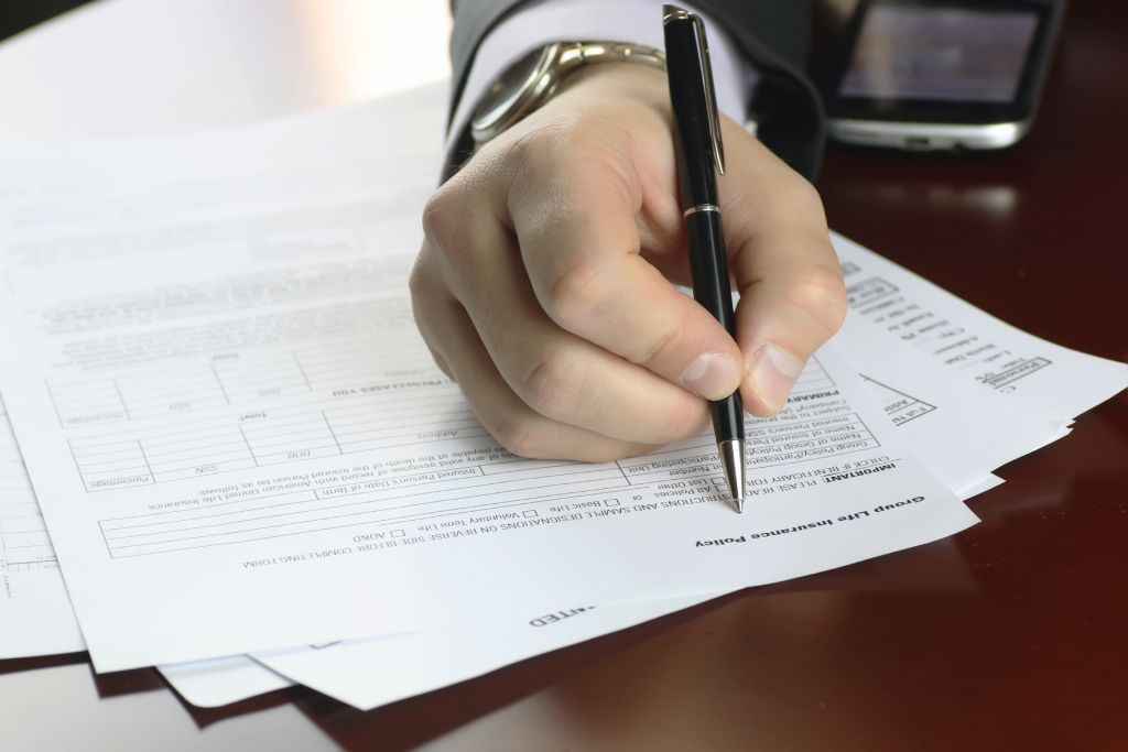 A hand signing escrow paperwork.